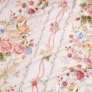 Posh Peanut - Janey
A close-up of a floral fabric with a vintage design, featuring pink and red roses, yellow tulips, blue flowers, and green leaves arranged in vertical diagonal stripes on a cream background.