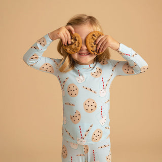 Posh Peanut Classic Pajama Set - Chocolate Chip Cookies
Child wearing a cookie-themed outfit holding cookies up to their eyes against a beige background