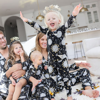Posh Peanut Classic Pajama Set - Midnight Bash
Family of five wearing matching pajamas with a child in the center wearing a star-shaped headband.