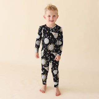 Posh Peanut Classic Pajama Set - Midnight Bash
Child wearing a black pajama set with celestial pattern on a beige background