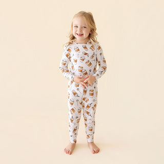 Posh Peanut Coffee Classic Pajama Set
Child wearing pajamas with a pattern of bottles and cups on a beige background