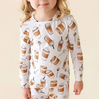 Posh Peanut Coffee Classic Pajama Set
Child wearing a long-sleeve shirt with coffee cup pattern on a beige background