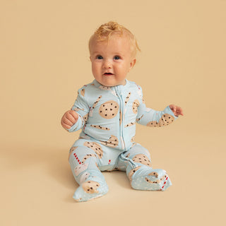 Posh Peanut Convertible One Piece - Chocolate Chip Cookies
Baby wearing a light blue onesie with animal prints on a beige background