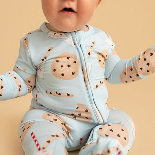 Posh Peanut Convertible One Piece - Chocolate Chip Cookies
Baby wearing a light blue onesie with cookie pattern on a beige background