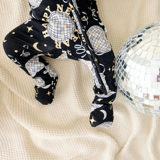 Posh Peanut Convertible One Piece - Midnight Bash
Black baby leggings with gold patterns on a beige blanket with a disco ball.