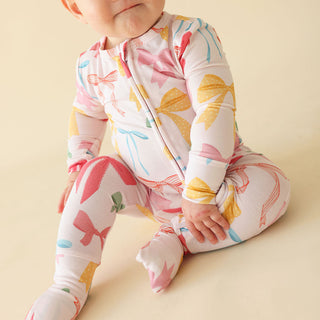 Posh Peanut Convertible One Piece - Shawna
Baby wearing a colorful floral onesie on a beige background