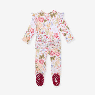 Posh Peanut Picot Footie Ruffled Zippered One Piece - Kristiana 
A baby footed one-piece jumpsuit with a pink and green floral rose pattern on a white base, featuring ruffled shoulder details and red polka-dot foot covers with a white monogram.