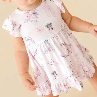 Posh Peanut Ruffled Twirl Bodysuit Dress - Piroutte
Child wearing a floral dress with pink flamingos on a beige background