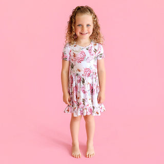 Posh Peanut Ruffled Twirl Dress - Lucienne
Young girl wearing a floral dress on a pink background