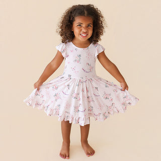 Posh Peanut Ruffled Twirl Dress - Pirouette
Young girl wearing a floral dress on a beige background