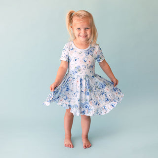 Posh Peanut Ruffled Twirl Dress - Trista
Young girl wearing a floral dress against a light blue background