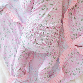 Posh Peanut Ruffled Zippered Footie - Annabeth
Pink floral baby crib set with ruffled details on a white background