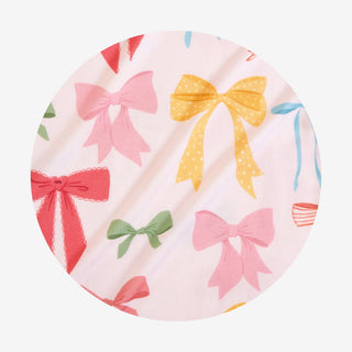 Posh Peanut Shawna
Round fabric patch with colorful bow pattern on a white background