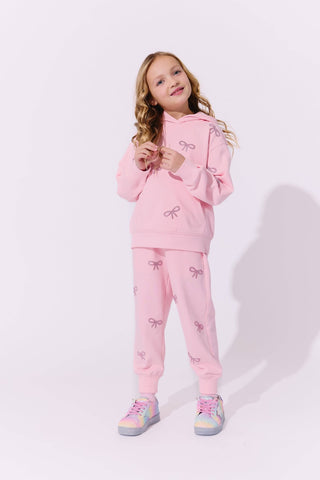 Lola and The Boys Pretty in Crystal Bows Set Young girl wearing a pink outfit with bow designs on a light background