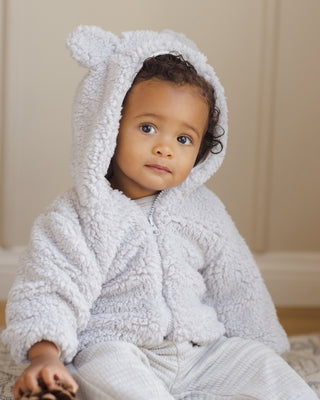 Quincy Mae Bear Jacket - Frost
Baby wearing a white textured robe with bunny ears sitting on a beige surface.