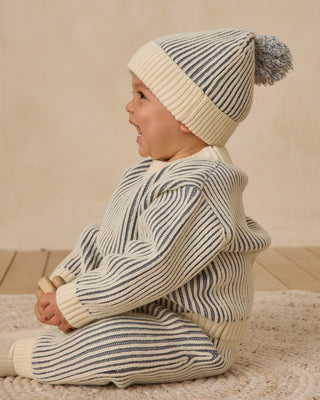 Quincy Mae Beanie - Ocean
Child wearing a striped sweater and hat on a wooden floor with a beige background