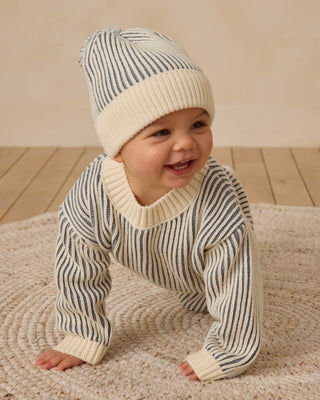 Quincy Mae Beanie - Ocean
Baby wearing a striped sweater and hat on a wooden floor.