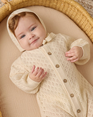 Quincy Mae Bubble Romper - Natural
Baby in a cream knitted outfit lying in a woven basket