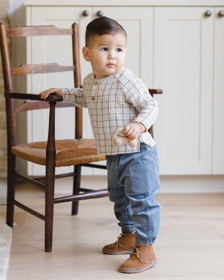 Quincy Mae Zion Shirt - Blue Plaid
Child standing in a room with wooden chair and white cabinets