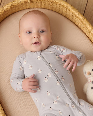 Quincy Mae Bamboo Zip Footie - Snowmen
Baby in a light gray onesie with snowman pattern lying in a crib with a snowman toy.