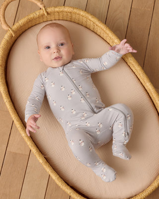 Quincy Mae Bamboo Zip Footie - Snowmen
Baby in a light gray onesie with floral patterns lying in a wicker basket on a wooden floor.