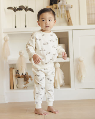 Quincy Mae Relaxed Fleece Sweatshirt & Relaxed Sweatpant Set - Bats
Child wearing a white pajama set with small patterns in a room with white walls and wooden floor.