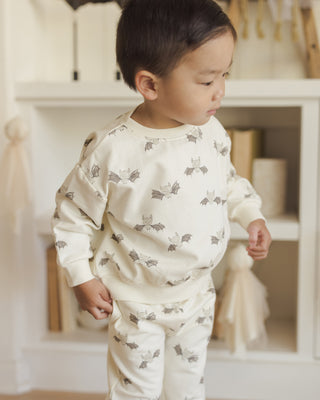 Quincy Mae Relaxed Fleece Sweatshirt & Relaxed Sweatpant Set - Bats
Child wearing a white outfit with gray animal prints in a home setting