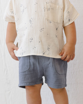 Quincy Mae Utility Short - Ocean
Child wearing a beige shirt with a subtle pattern and blue shorts on a plain background