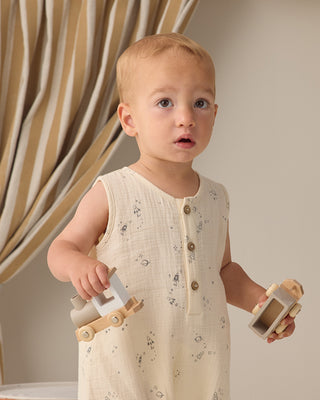 Quincy Mae Jack Romper - Space
Baby in a floral dress holding wooden toys against a neutral background