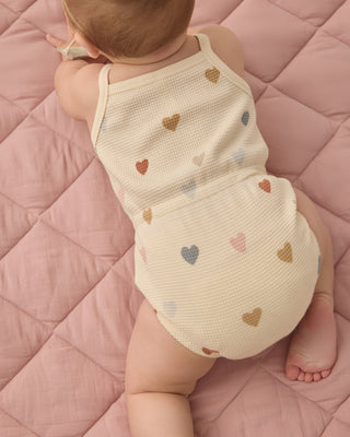 Quincy Mae waffle cinch romper for babies with confetti hearts pattern, soft fabric, and adjustable waist for comfortable fit.