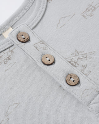 Quincy Mae Short Sleeve One Piece - Airplanes
Close-up of a light gray fabric with embroidered patterns and buttons.