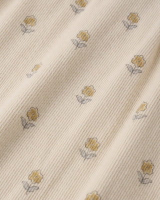 Quincy Mae ribbed buttercup-colored ruffle romper for infants, featuring textured fabric and delicate ruffle details.