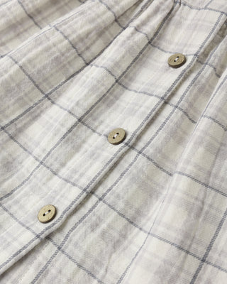 Quincy Mae Alina Dress - Blue Plaid
Close-up of a checkered shirt with buttons on a light background