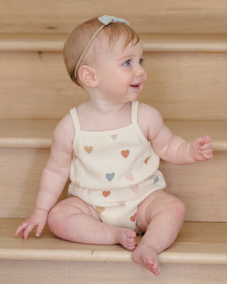 Quincy Mae waffle cinch romper in confetti hearts pattern, soft fabric with a stylish fit, perfect for babies or toddlers.