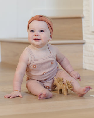 Quincy Mae pink daisy waffle cinch romper for babies, featuring a soft fabric and waist tie in a cozy, stylish design.