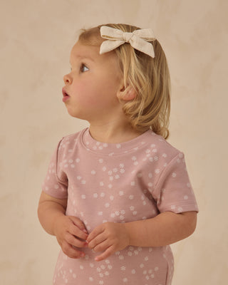 Quincy Mae Bow w/Clip Set - Natural + Mauve + Sage
Young child wearing a pink floral dress with a bow in their hair against a beige background