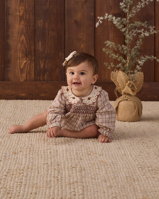 Quincy Mae Callie Romper in Christmas plaid featuring long sleeves and a festive pattern for baby girl.