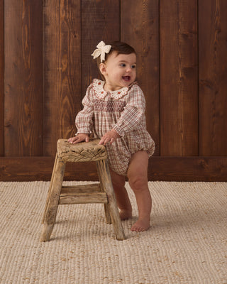 Baby girl Quincy Mae Callie Romper in Christmas plaid fabric, soft and cozy for holiday wear.