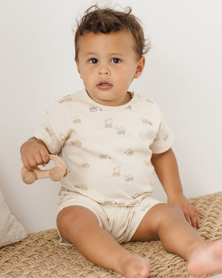 Quincy Mae Frankie Set - Construction
Baby sitting on a woven surface holding a wooden toy, wearing a patterned onesie.