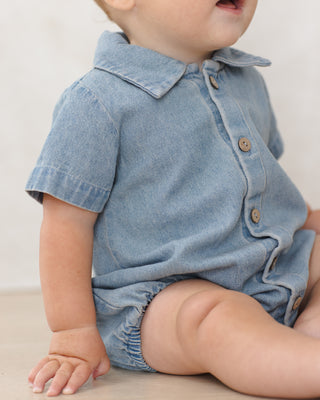 Quincy Mae Matteo Romper - Chambray
Baby wearing a denim romper with a plain background