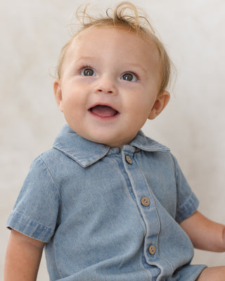 Quincy Mae Matteo Romper - Chambray
Baby wearing a denim outfit with a plain background