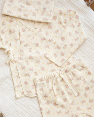 Quincy Mae Wrap Top & Pant Set - Flower Field
Floral-patterned baby blanket on a textured surface