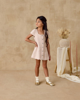 Noralee Gabrielle Dress - Rose
Young girl in a white dress standing in a studio with a neutral background