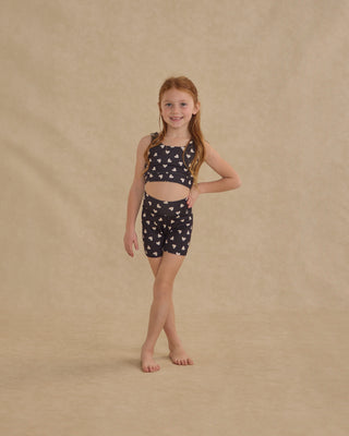 Play by Rylee & Cru Swift Sports Bra - Hearts
Young girl wearing a black and white patterned outfit on a beige background