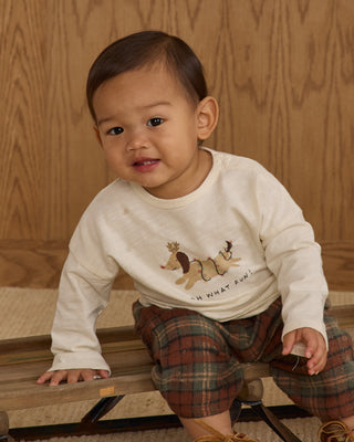 Rylee & Cru Long Sleeve Tee - Oh What Fun
Child wearing a white shirt with a graphic design sitting on a wooden floor.