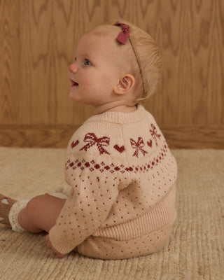 Rylee & Cru Fairisle Sweater - Bows
Baby wearing a pink knitted sweater with red patterns, sitting on a wooden floor.