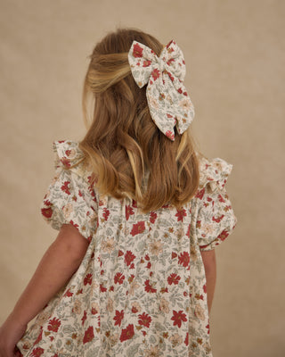 Rylee & Cru Oversized Bow - Holiday Floral
Child wearing a floral dress and hair bow against a beige background