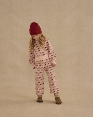 Rylee & Cru Jacquard Knit Set - Ruby Hearts
Child wearing a patterned outfit with a red hat on a beige background
