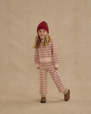 Rylee & Cru Jacquard Knit Set - Ruby Hearts
Child wearing a red knit hat and patterned pajama set on a beige background