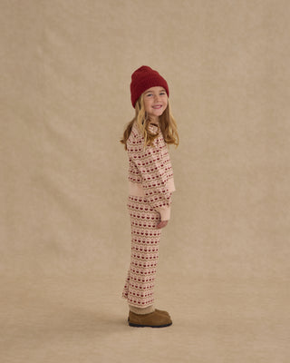 Rylee & Cru Jacquard Knit Set - Ruby Hearts
Child wearing a patterned outfit and red hat on a beige background